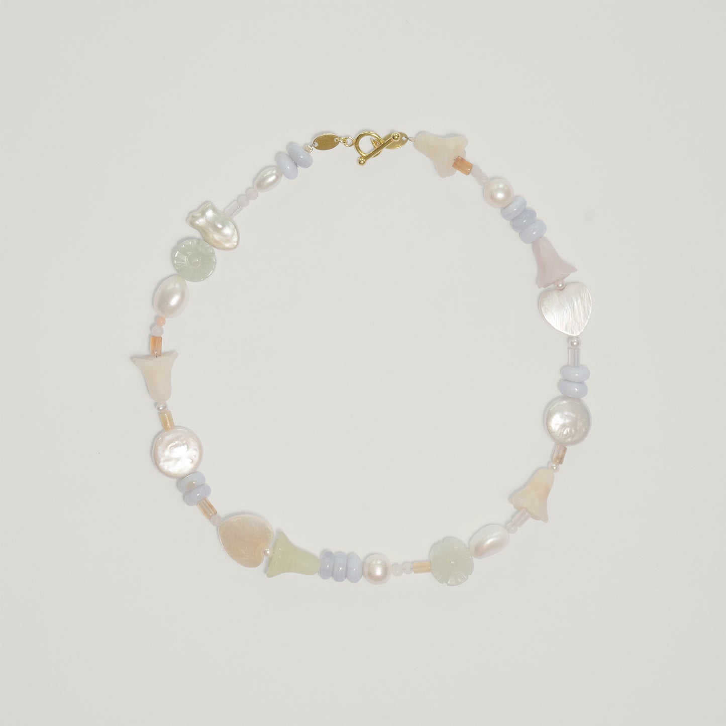 Entdecke Frellinis Halskette aus Süßwasserperlen, Serpentin, Rosenquarz, Chalcedon und Koralle mit Knebelverschluss. Schmuckdesign aus Hamburg.