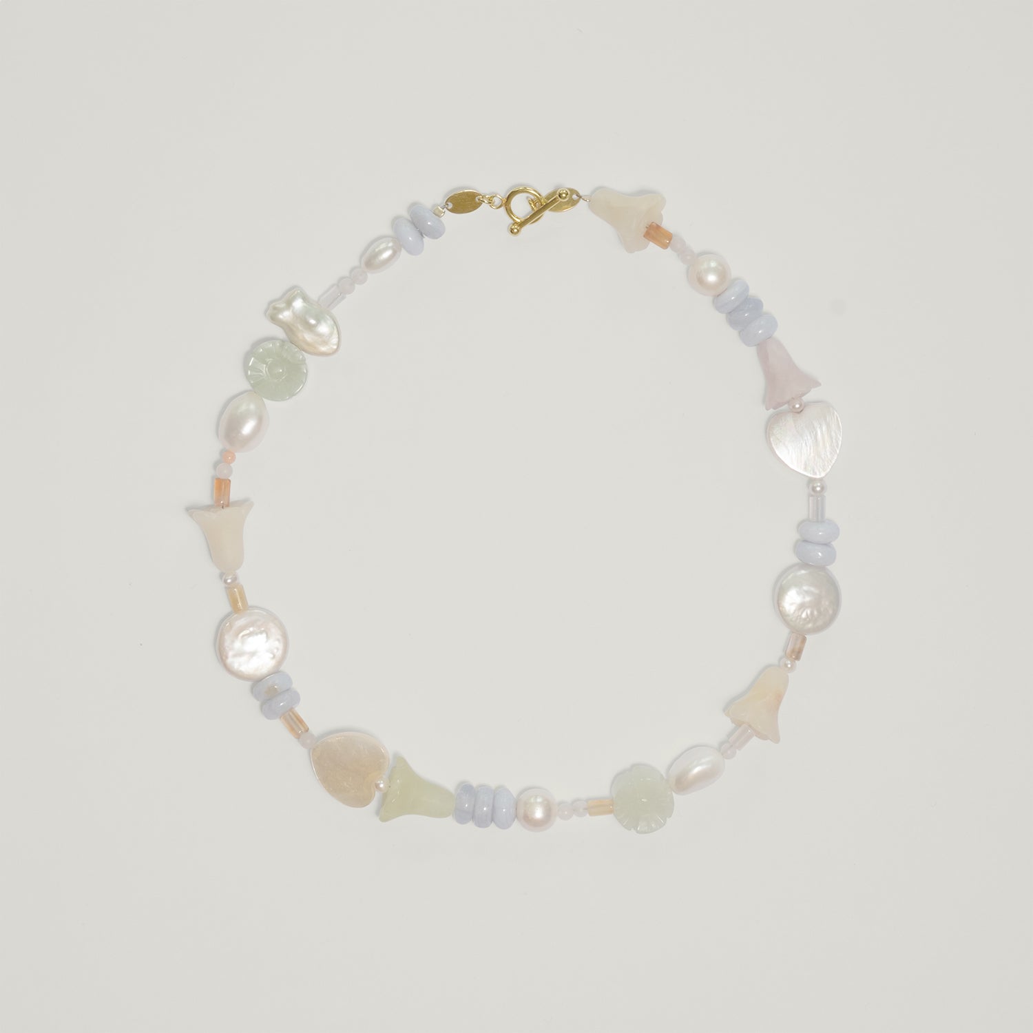 Entdecke Frellinis Halskette aus Süßwasserperlen, Serpentin, Rosenquarz, Chalcedon und Koralle mit Knebelverschluss. Schmuckdesign aus Hamburg.