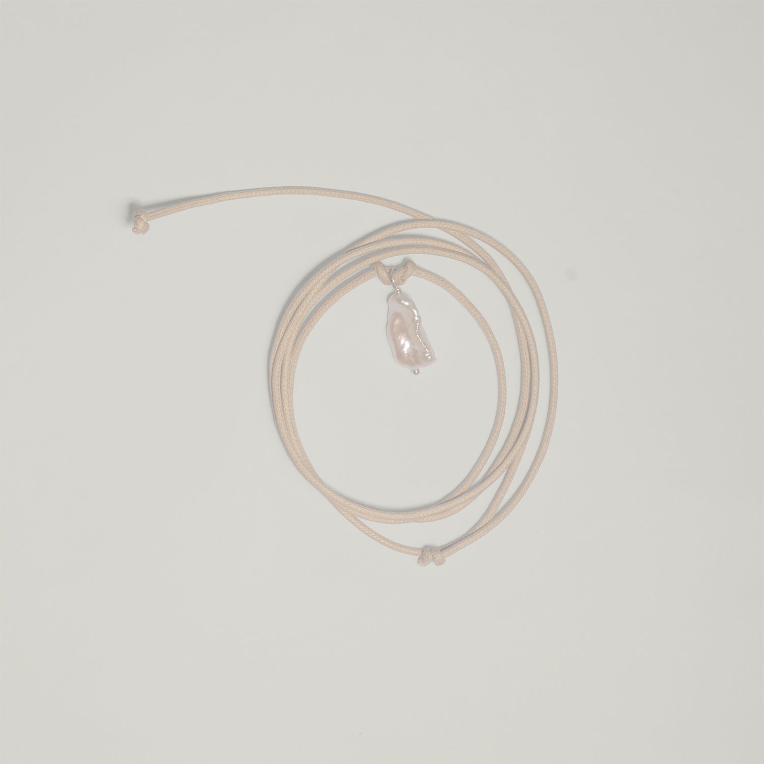 Entdecke Frellinis Kette Minu zum Binden aus Baumwolle mit einer Süßwasserperle als Anhänger. Schmuckdesign aus Hamburg.