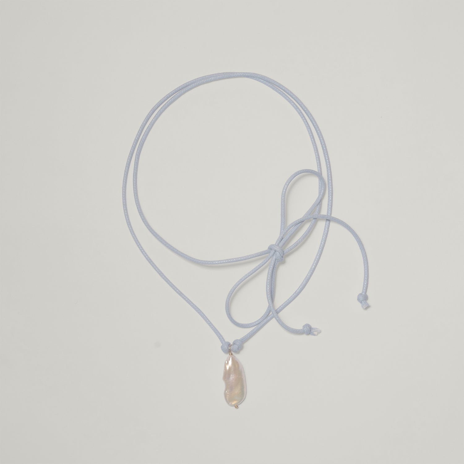 Entdecke Frellinis Kette Minu zum Binden aus Baumwolle mit einer Süßwasserperle als Anhänger. Schmuckdesign aus Hamburg.