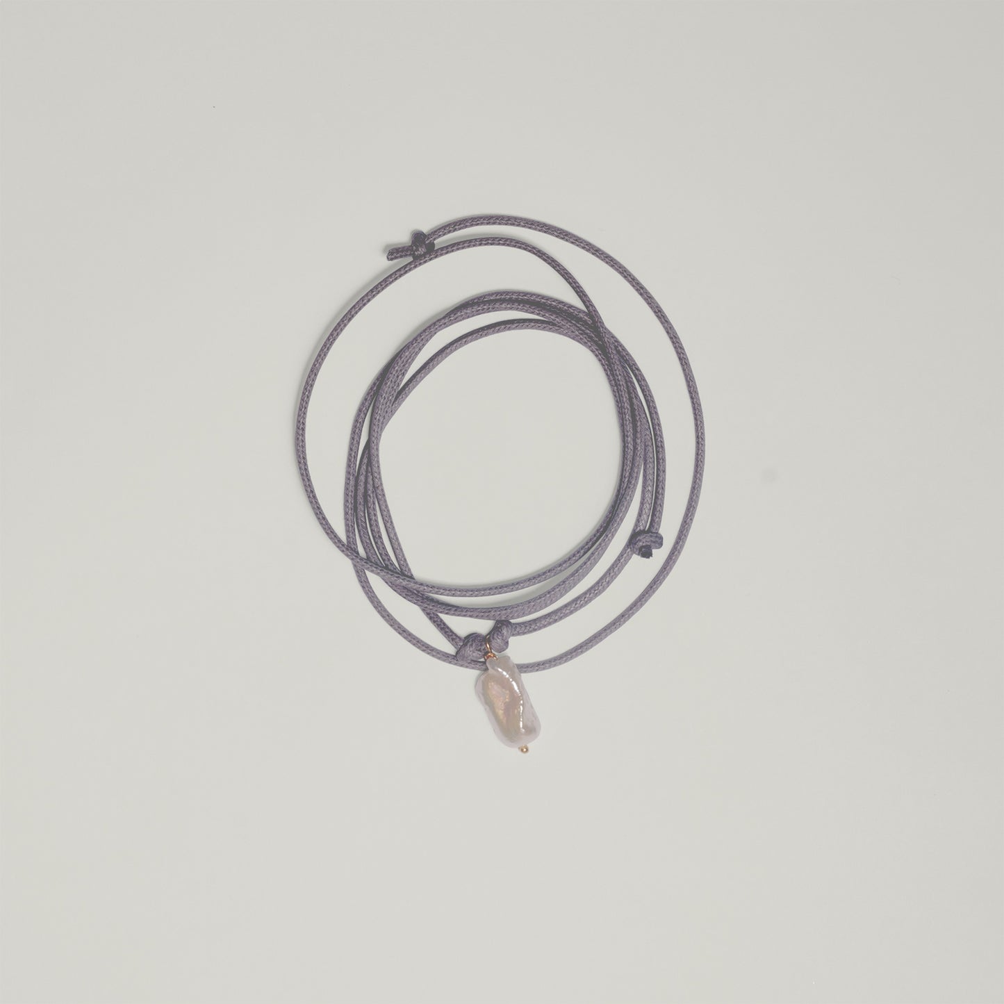 Entdecke Frellinis Kette Minu zum Binden aus Baumwolle mit einer Süßwasserperle als Anhänger. Schmuckdesign aus Hamburg.