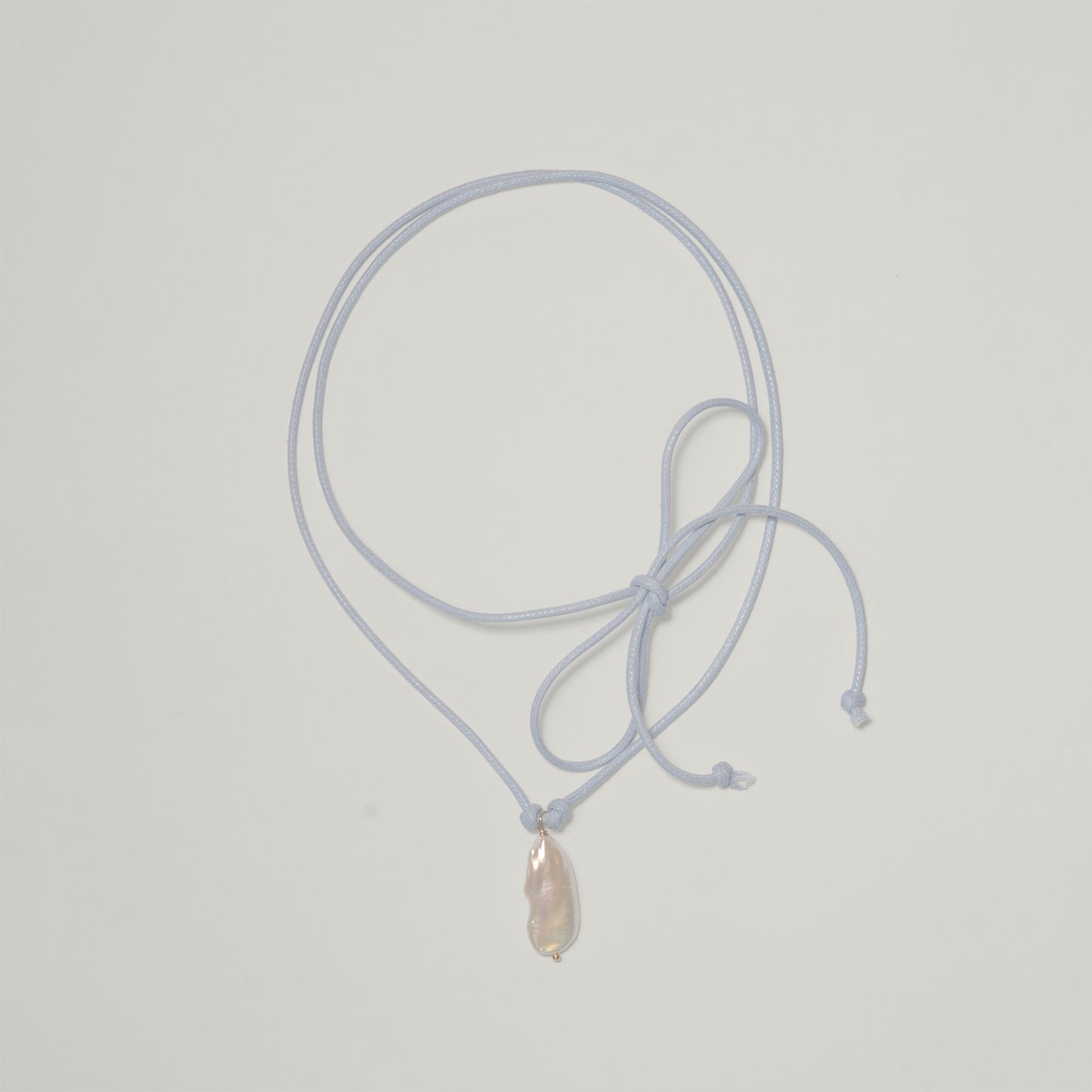 Entdecke Frellinis Kette Minu zum Binden aus Baumwolle mit einer Süßwasserperle als Anhänger. Schmuckdesign aus Hamburg.